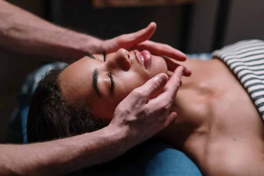 A woman laying on her back enjoying a face massage